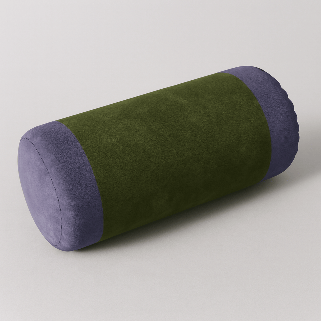 Green and purple cylindrical pillow on a light gray background