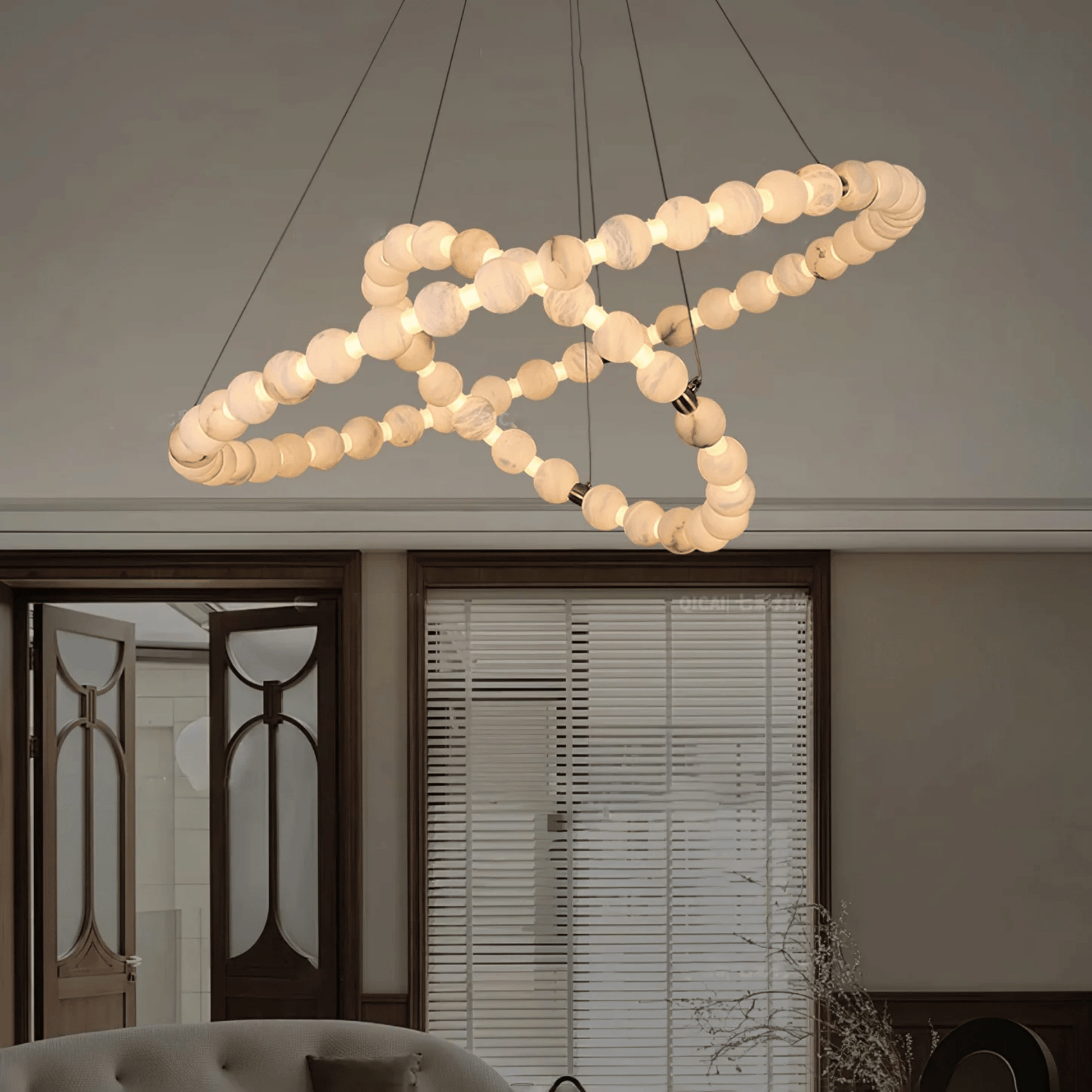 Modern chandelier with circular design hanging in a room.