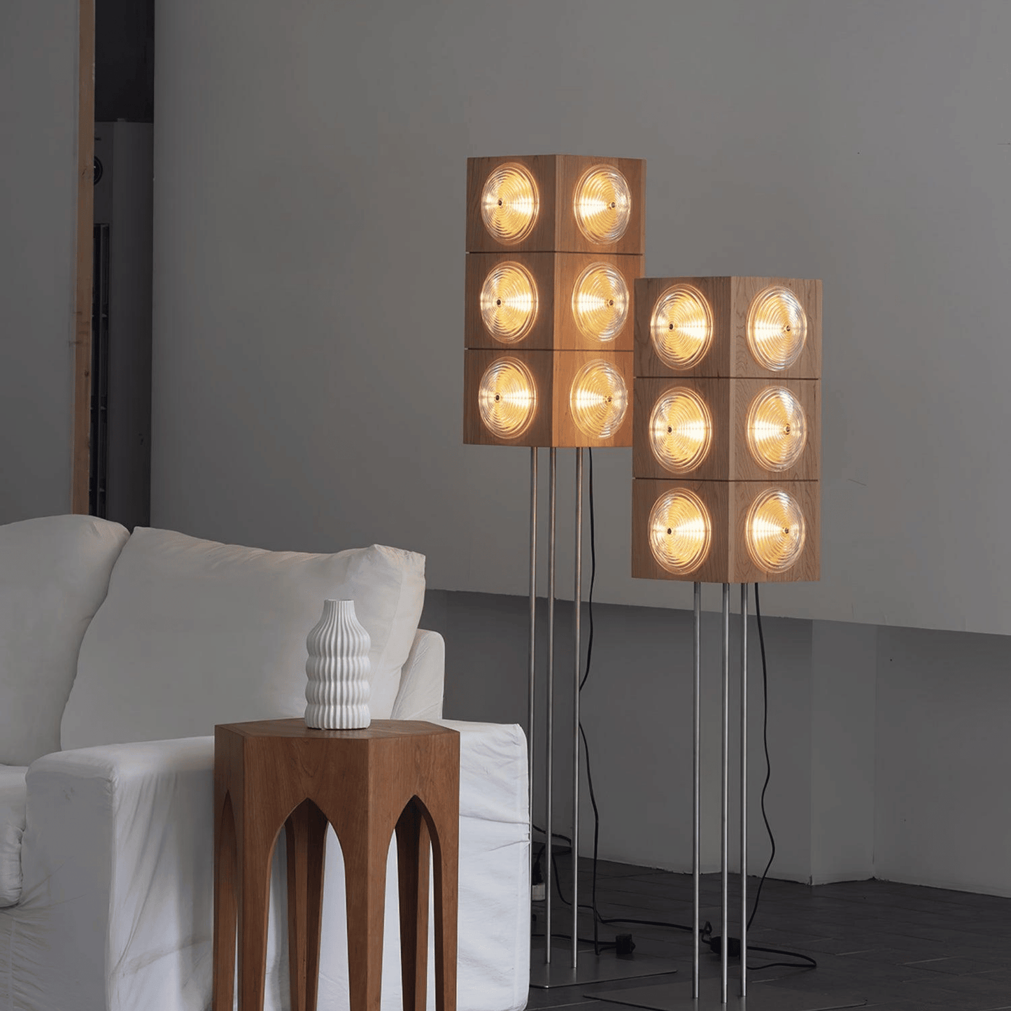 Modern floor lamp with square wooden panels and glass lights in a living room setting.