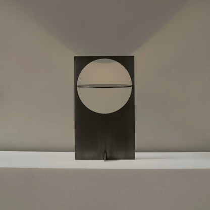 Modern wall-mounted light fixture with a circular design on a neutral background