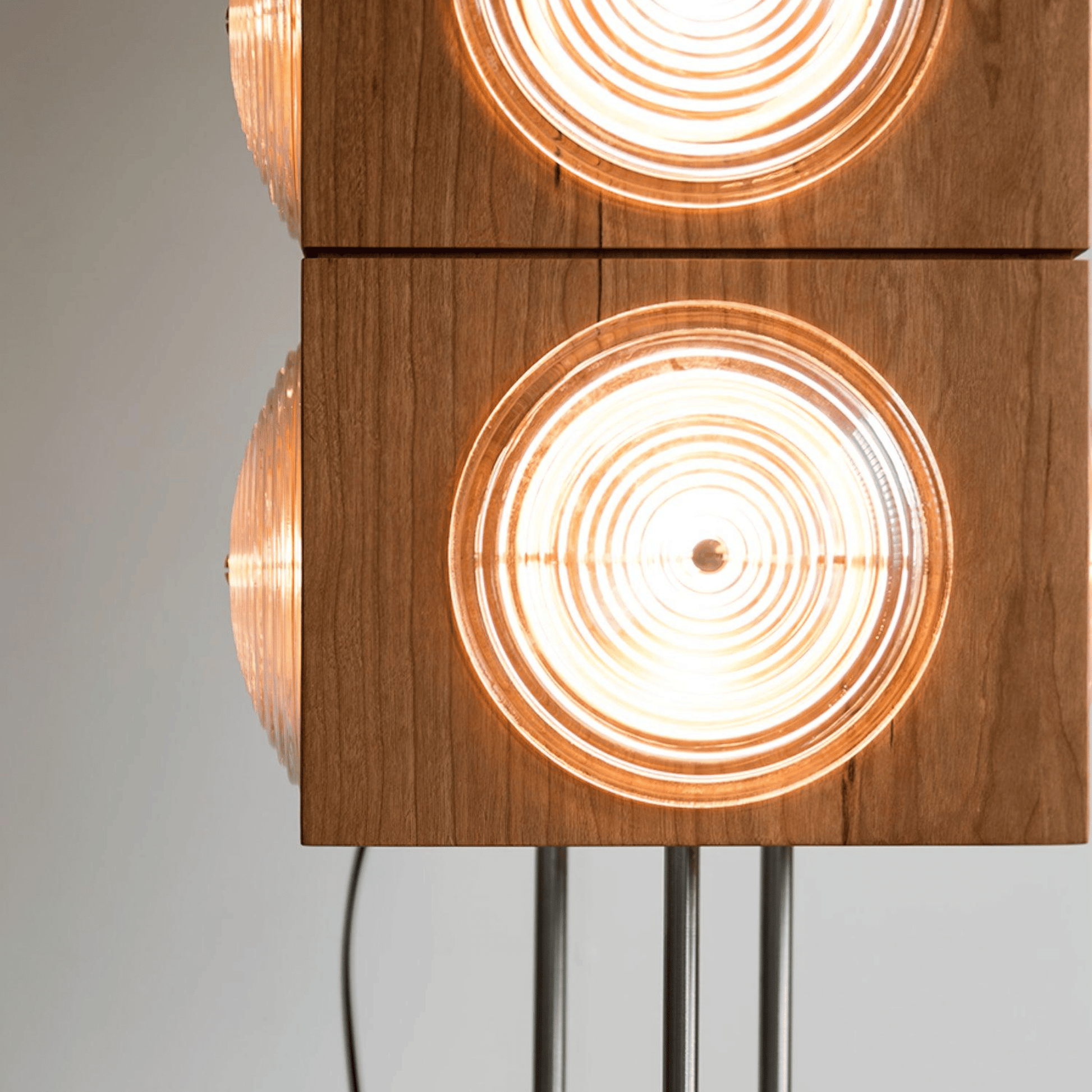 Wooden lamp with circular light fixtures on a gray background