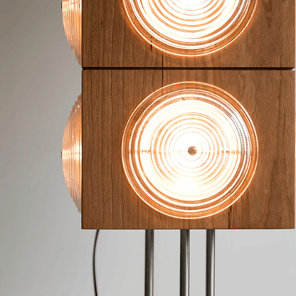 Wooden lamp with circular light fixtures on a gray background