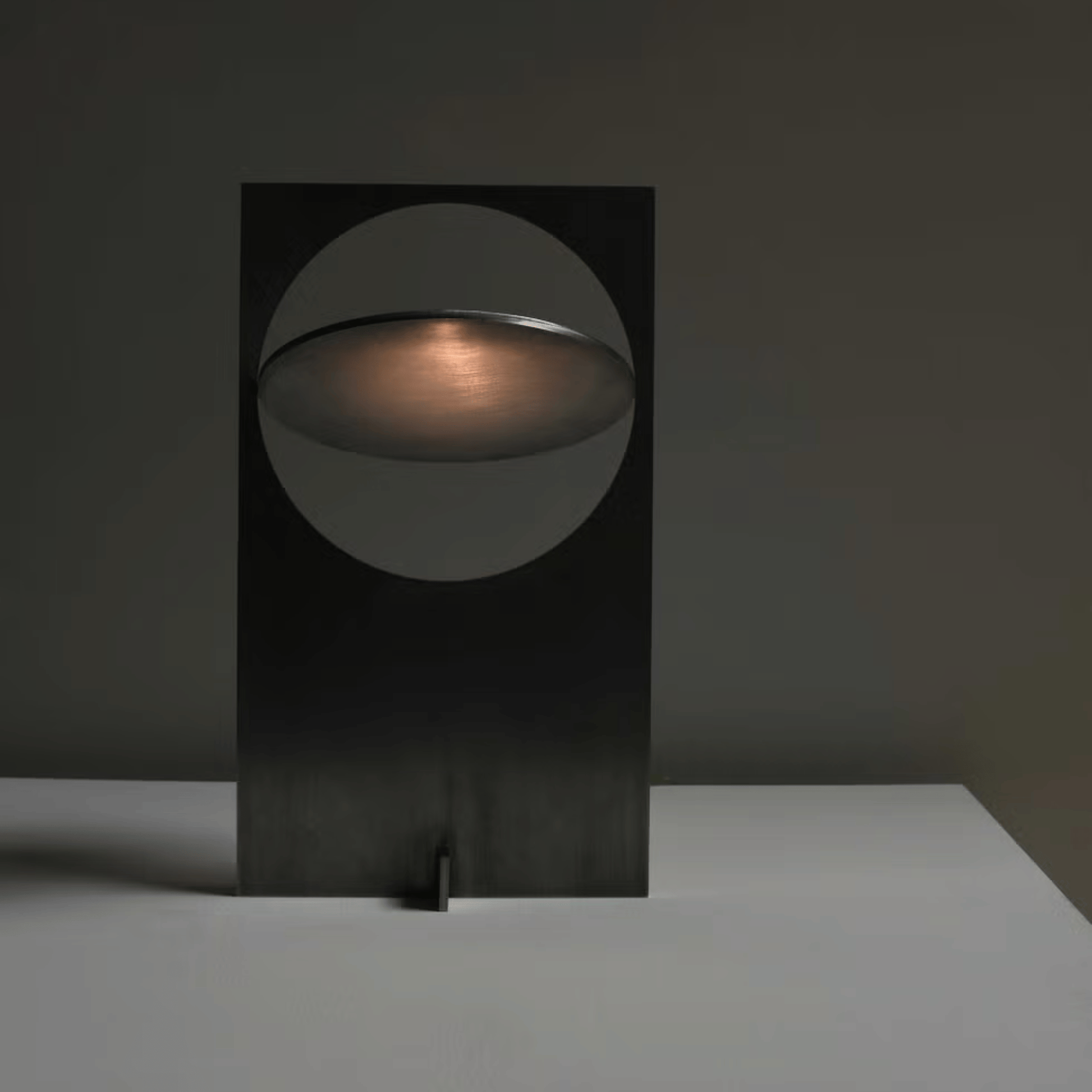 Modern black table lamp with a circular design on a dark background