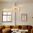 Modern living room with a chandelier, brown sectional sofa, and abstract art on the wall.
