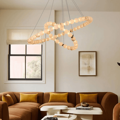 Modern living room with a chandelier, brown sectional sofa, and abstract art on the wall.