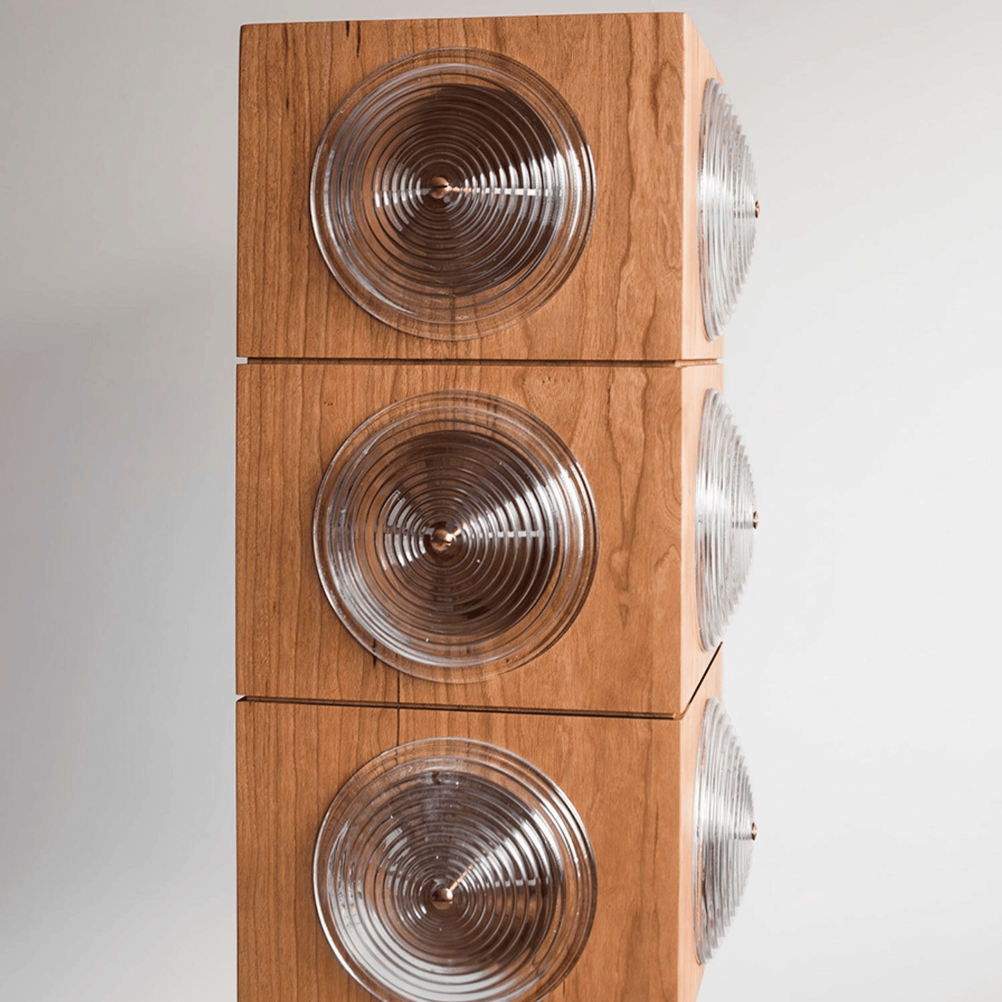 Wooden speaker with circular design on a white background