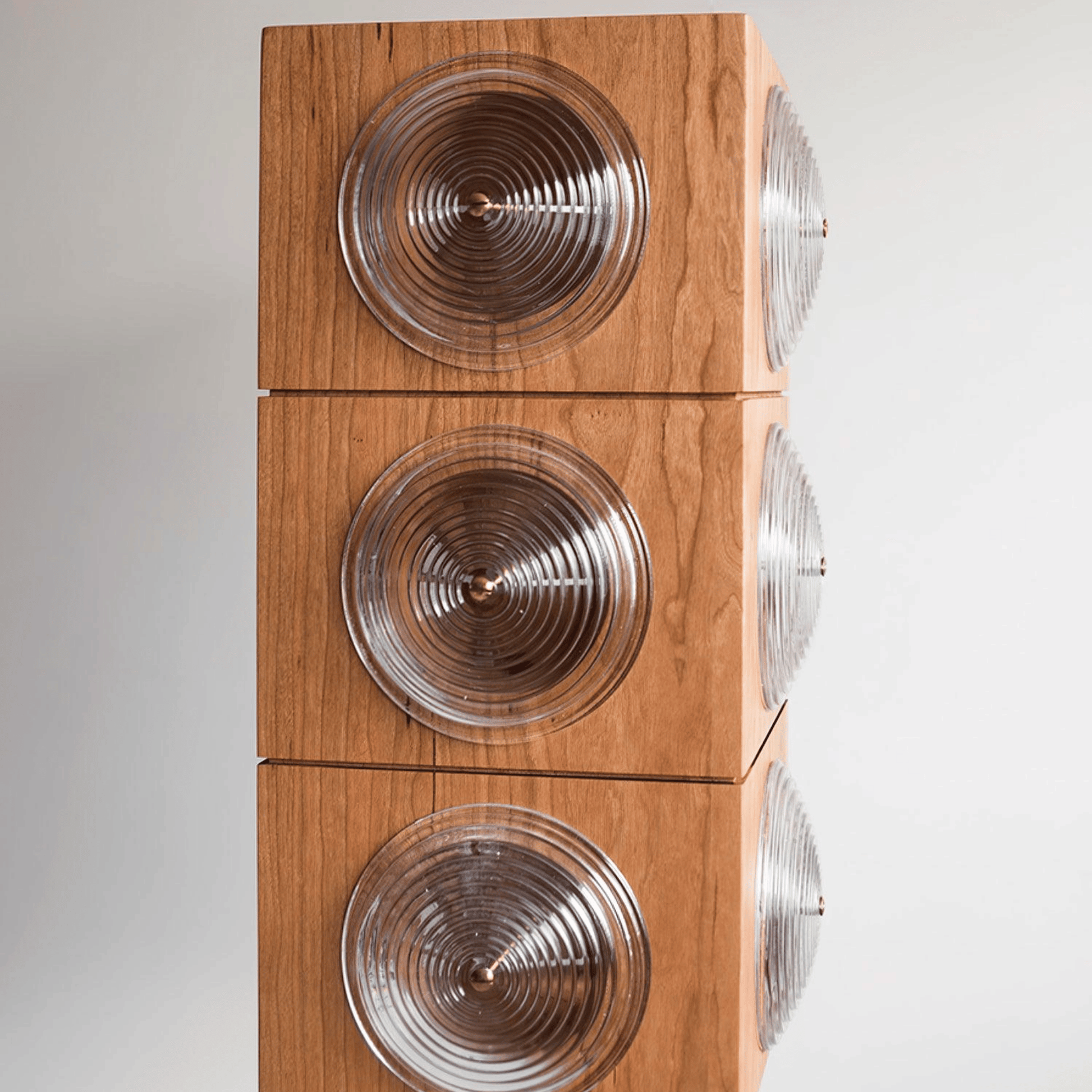 Wooden speaker with circular design on a white background