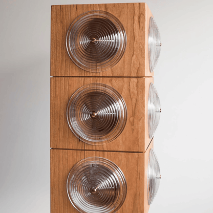 Wooden speaker with circular design on a white background