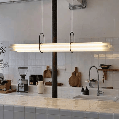 Modern kitchen with a long linear pendant light fixture.