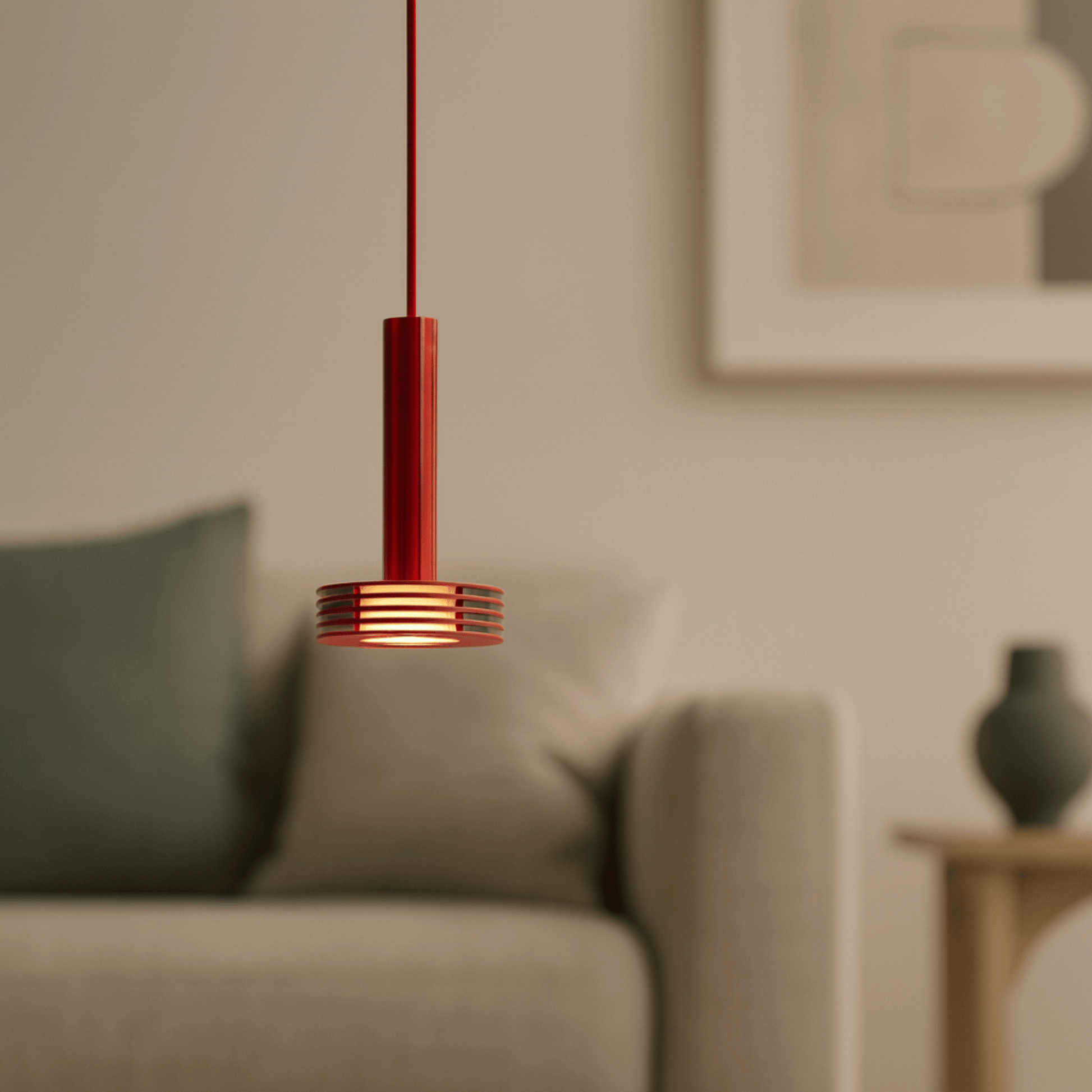Red pendant light hanging in a living room with a blurred background