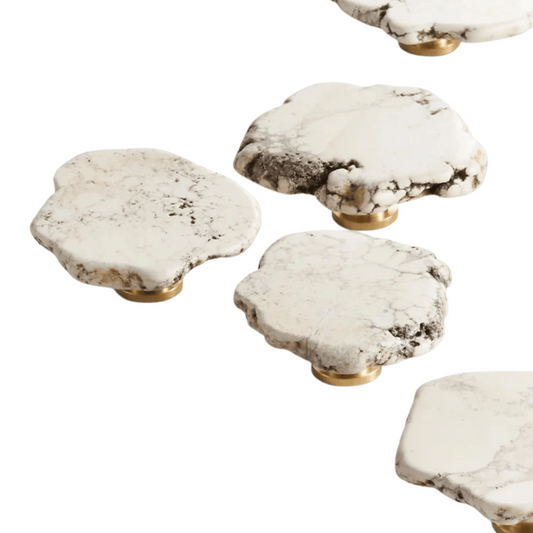Set of five marble-patterned coasters with gold bases on a white background