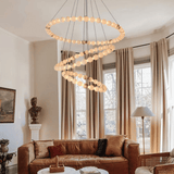 Living room with a modern chandelier, brown sofa, and large windows.
