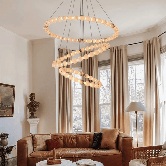 Living room with a modern chandelier, brown sofa, and large windows.