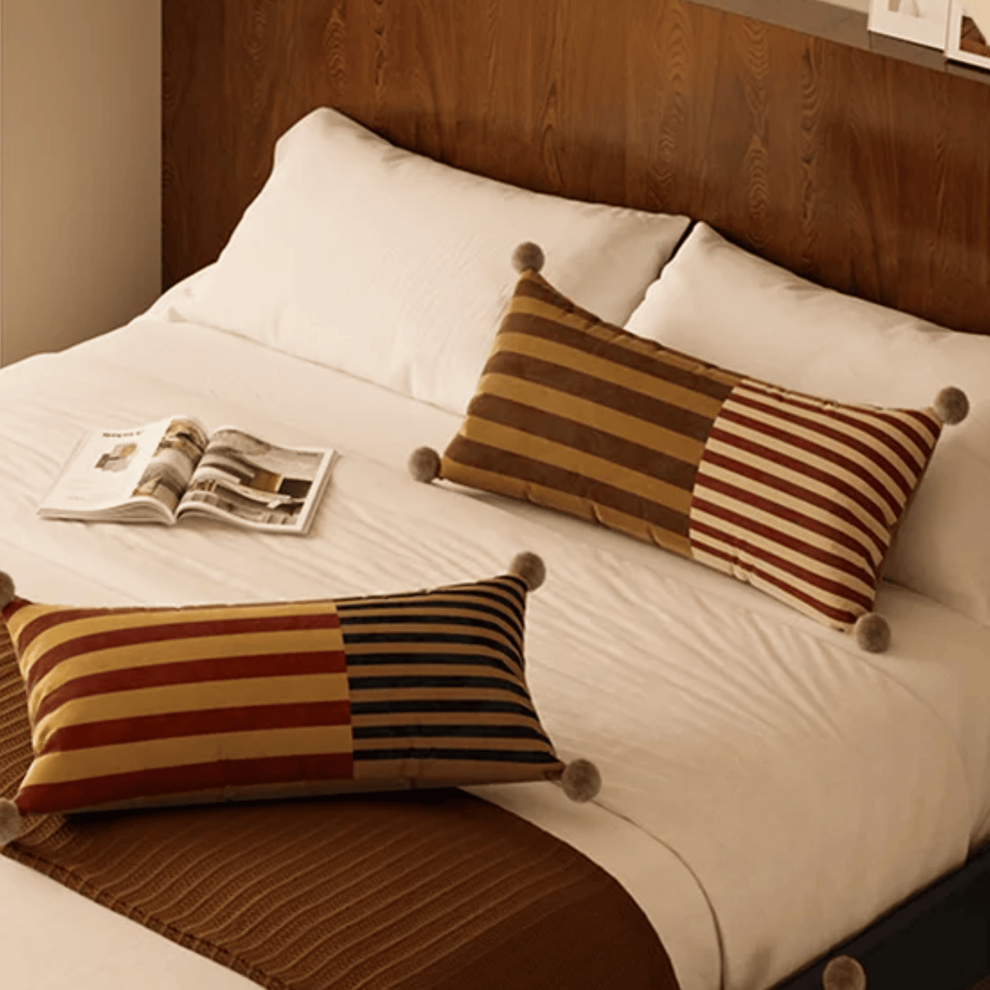 Bed with striped pillows and a newspaper on a wooden headboard