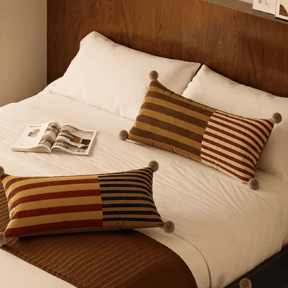 Bed with striped pillows and a newspaper on a wooden headboard