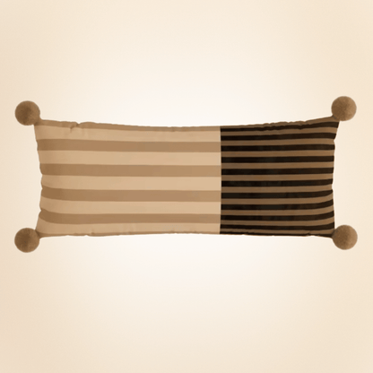 Decorative pillow with striped pattern and pom-pom accents on a beige background