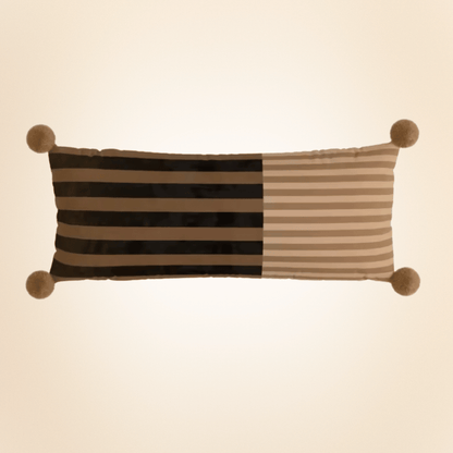 Striped pillow with pom-pom accents on a beige background
