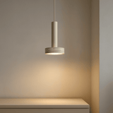 Modern pendant light hanging above a table with a neutral background