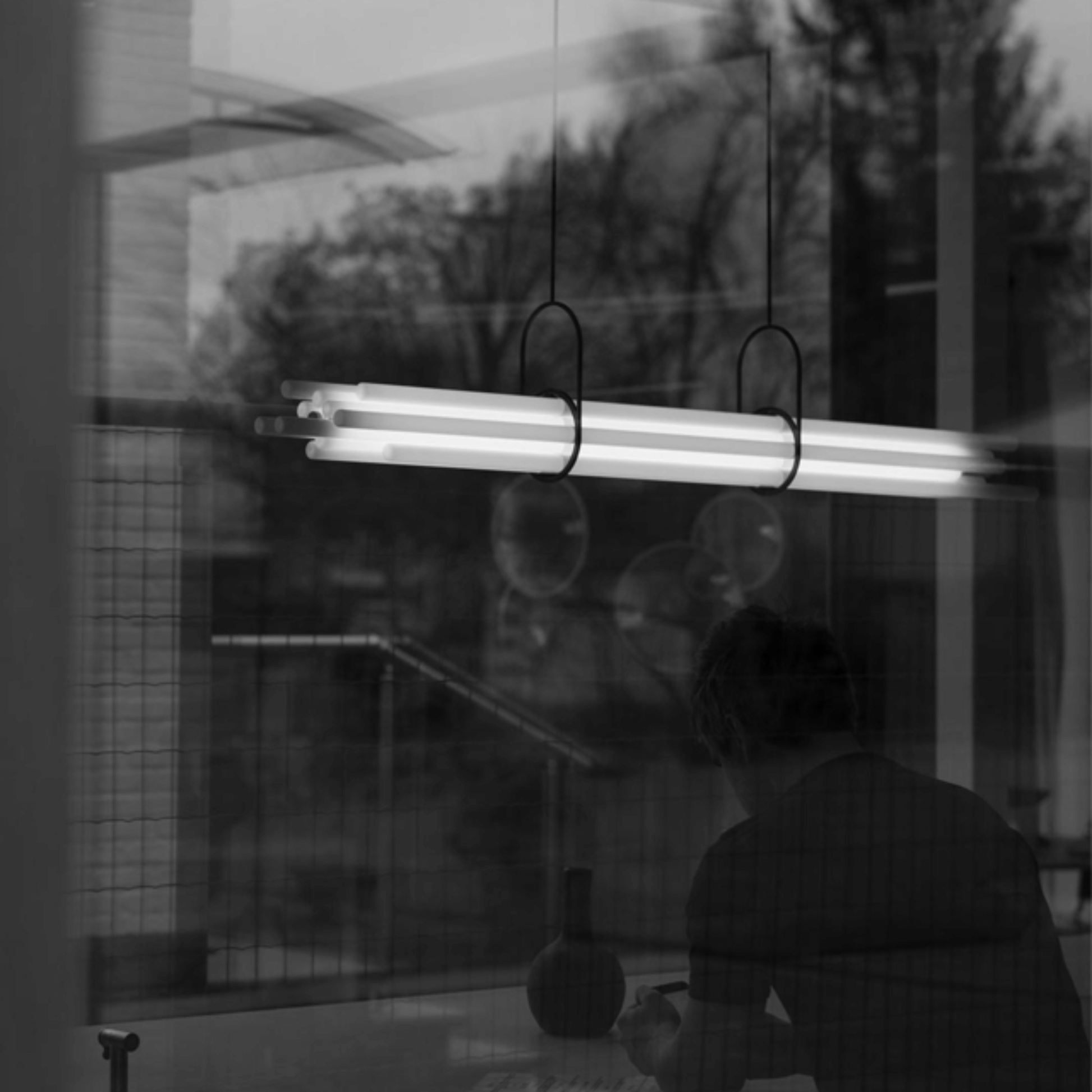Person cleaning a window with a squeegee and glass cleaner, reflected in the glass.