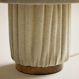 Close-up of a textured ceramic vase with a ribbed design on a neutral background