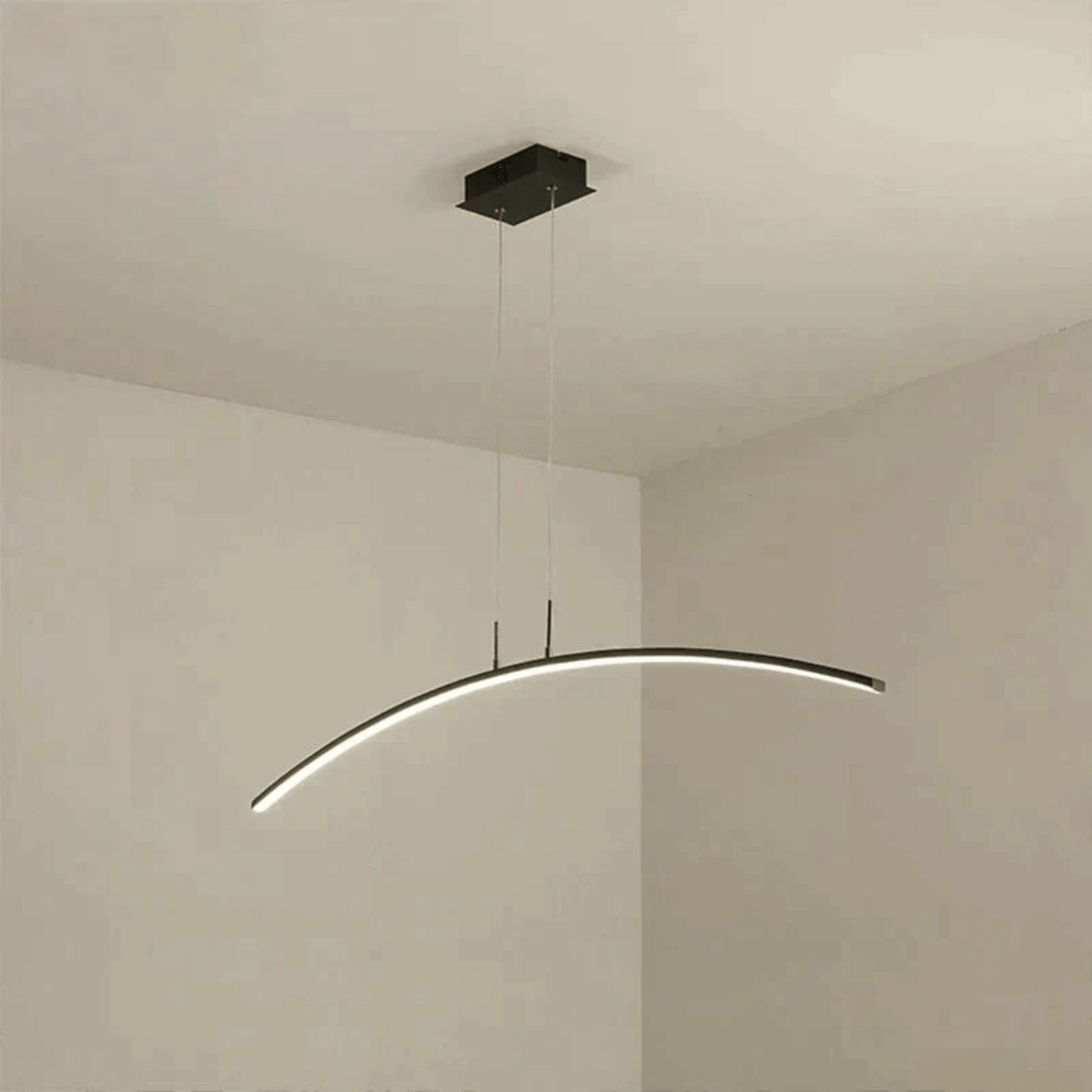 Modern pendant light fixture hanging from the ceiling in a minimalistic room.