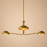 Gold chandelier with three arms on a beige background