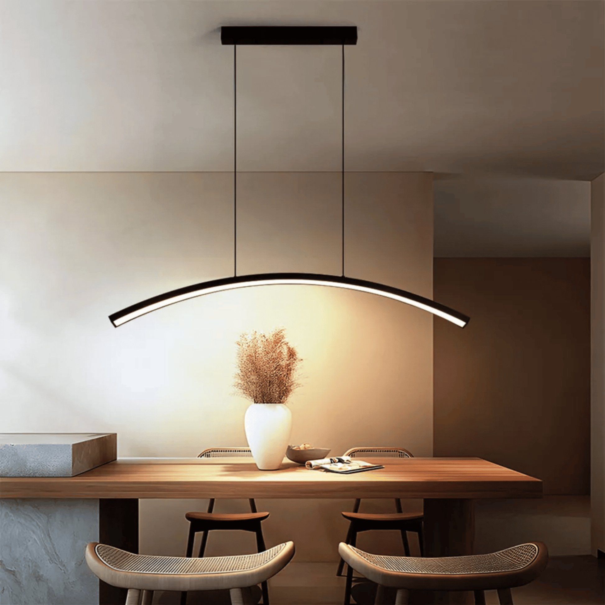 Modern pendant light hanging above a dining table with chairs in a minimalistic setting.