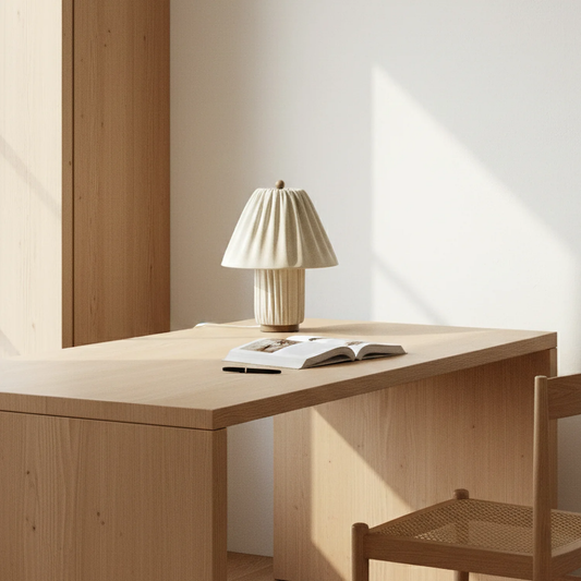 Wooden desk with a lamp and open book in a minimalistic room.