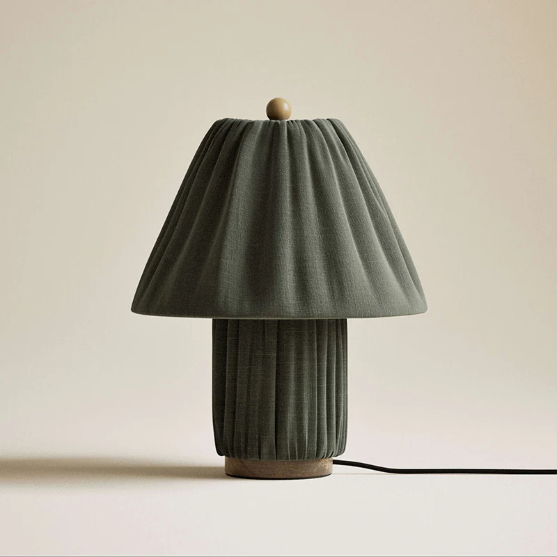 Green table lamp with pleated design on a beige background