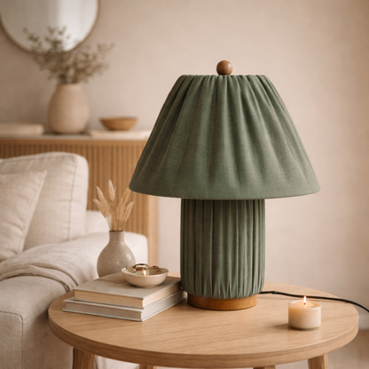 Green table lamp on a wooden table with a cozy living room background