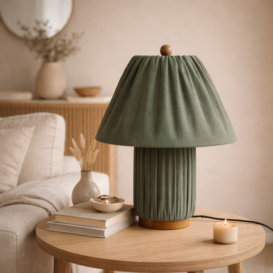 Green table lamp on a wooden table with a cozy living room background