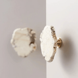 Close-up of two marble-patterned door knobs on a white door.