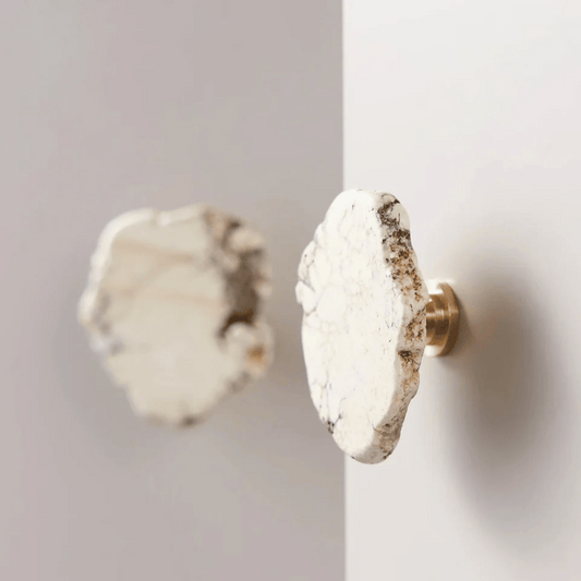 Close-up of two marble-patterned door knobs on a white door.