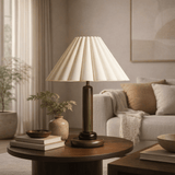Lamp on a wooden table in a living room setting with a couch and decor.
