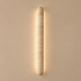 Cylindrical wall light fixture on a beige wall