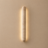 Cylindrical wall light fixture on a beige wall