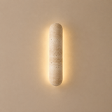 Cylindrical wall light fixture on a beige wall