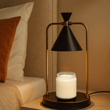 Modern table lamp with black cone-shaped shade and gold accents on a beige background