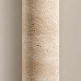 Close-up of a cylindrical stone-like object with a textured surface on a gradient background.