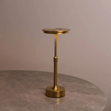 Gold candle holder on a gray surface with a neutral background