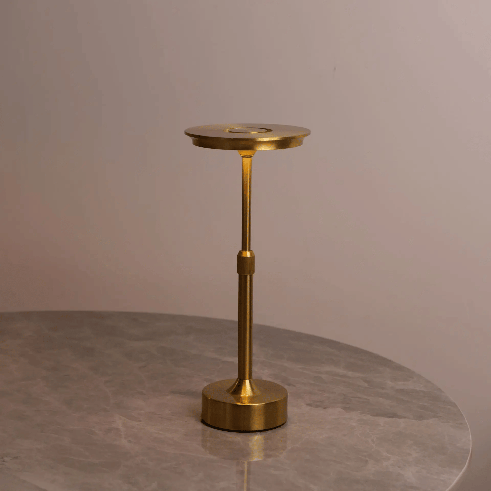 Gold candle holder on a gray surface with a neutral background