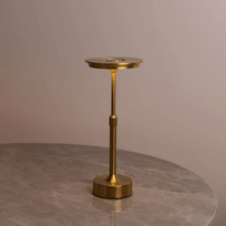 Gold candle holder on a gray surface with a neutral background