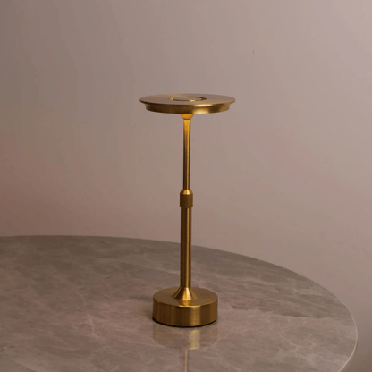Gold candle holder on a gray surface with a neutral background