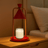 Modern table lamp with red cone-shaped shade and gold accents on a beige background
