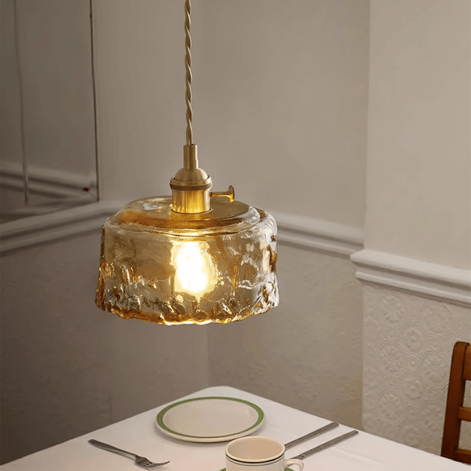 Pendant light with a textured glass shade hanging above a dining table.