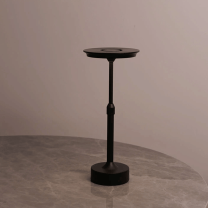 Black adjustable stand on a gray surface with a neutral background