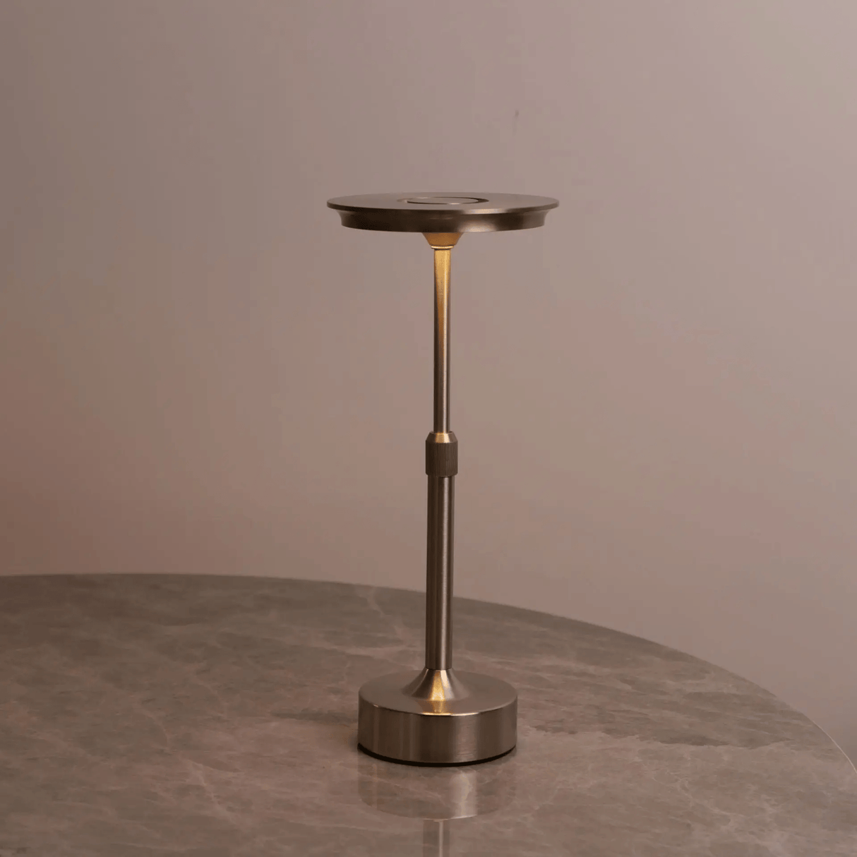 Bronze-colored lamp on a gray surface with a neutral background