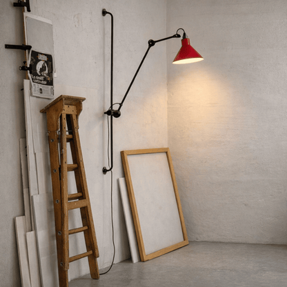 Wooden ladder, framed mirror, and wall-mounted lamp with red shade in a room.