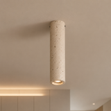 Cylindrical concrete ceiling light fixture on a neutral ceiling.
