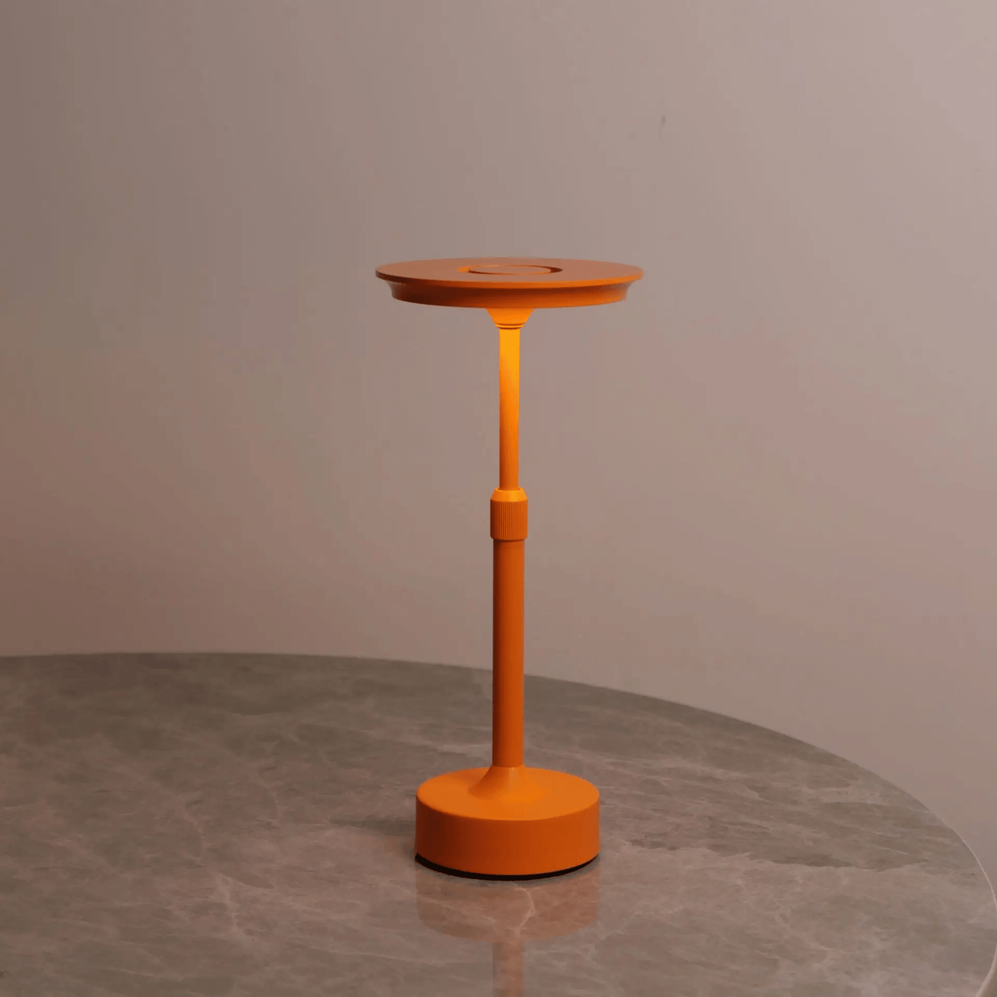 Orange adjustable stand on a gray surface with a neutral background